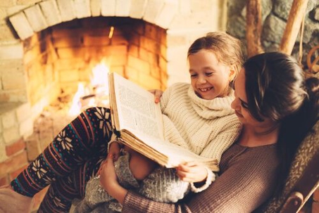Girl reading book with mom